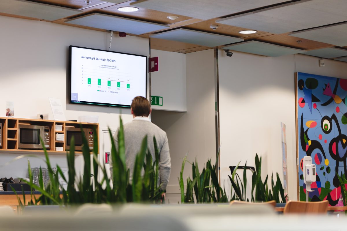 a man looking at a digital signage screen in an office