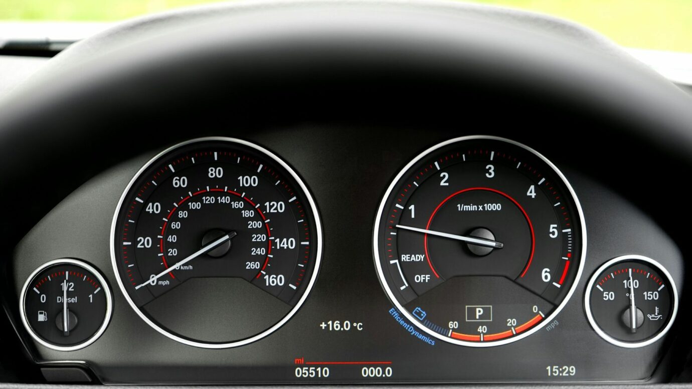 Detailed view of a car's speedometer and tachometer displaying gauges and indicators.