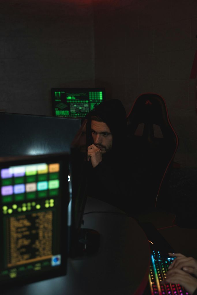 Man in Black Hoodie Sitting on Chair