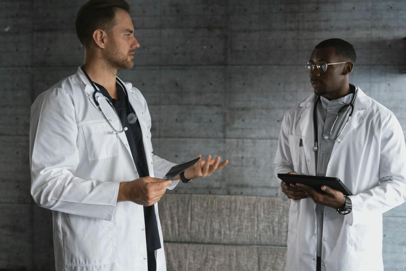 Two doctors in a modern workspace discussing patient care and medical research.